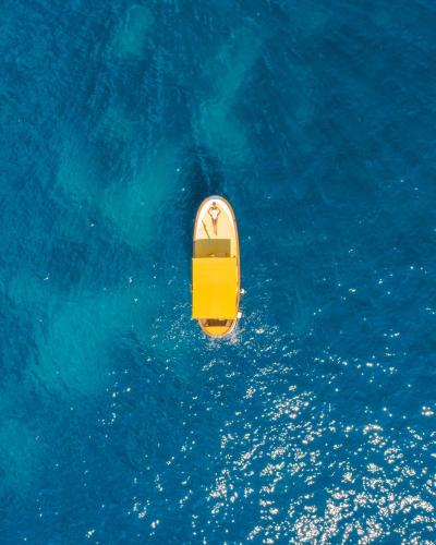 an overhead view of a yellow boat in the blue water at Hotel La Palma, Oetker Hotels in Capri