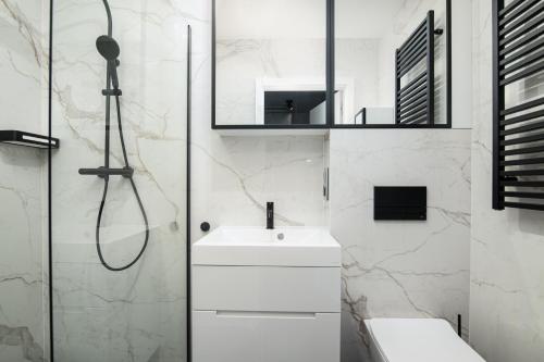 baño blanco con ducha y lavamanos en DOMKI CAŁOROCZNE STELLA PUCK, en Puck