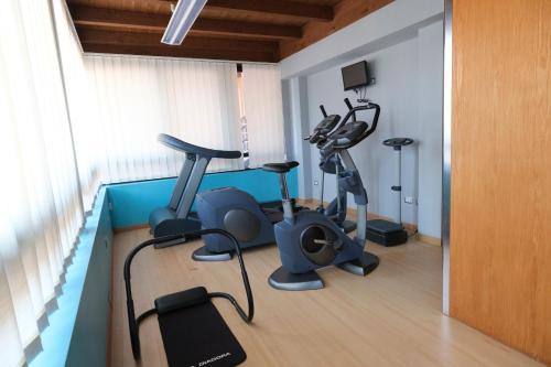a gym with treadmills and exercise bikes in a room at Albergo Zoello Je Suis in Castelvetro di Modena
