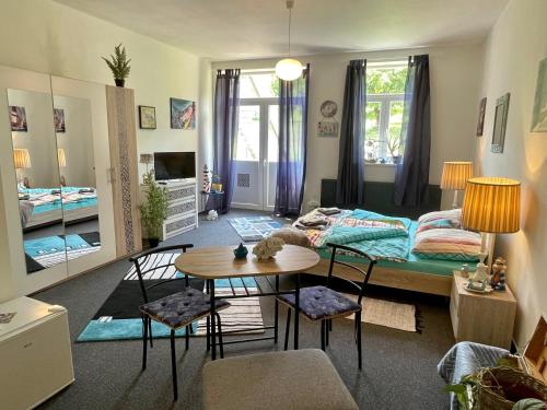 ムラダー・ボレスラフにあるPenzion Villa Amélieのベッド、テーブル、椅子が備わる客室です。