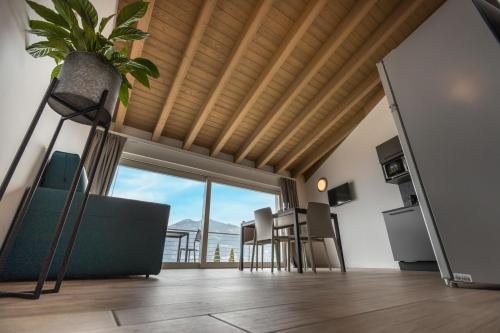 a living room with a table and chairs and a plant at Residence Solei Classic & Plus in Brenzone sul Garda