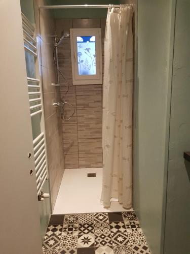 W łazience znajduje się prysznic z zasłoną prysznicową. w obiekcie Chambres d'hôtes couleur bassin d'Arcachon w mieście Andernos-les-Bains
