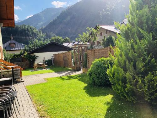 a backyard with green grass and a fence at Familienappartements Eder - Free entry to Tauern SPA Kaprun included in Kaprun