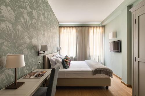 a bedroom with a bed and a desk and a window at Hotel Porta San Mamolo in Bologna