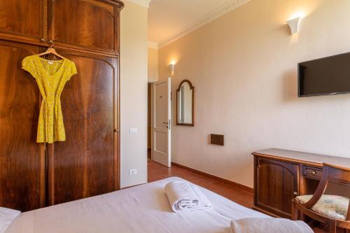 a bedroom with a dress hanging on a wooden wall at Hotel Villa San Michele in Lucca