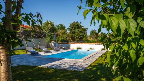 basen na dziedzińcu z 2 leżakami w obiekcie Stone house Furlani with a lovely garden w mieście Svetvinčenat