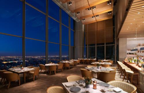 a restaurant with tables and chairs and large windows at Four Seasons Hotel Kuwait at Burj Alshaya in Kuwait