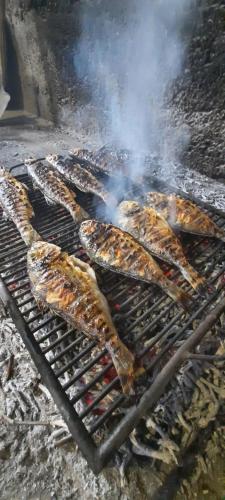 a bunch of food cooking on a grill at Apartmani Dejan in Skradin