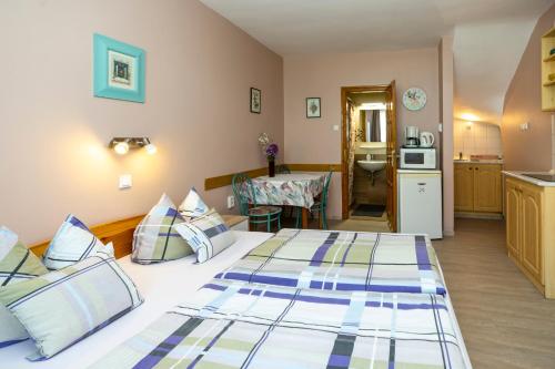 a hotel room with two beds and a kitchen at Cecey Apartman in Eger