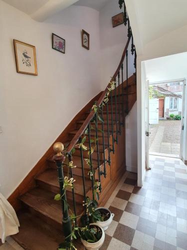 a staircase in a house with potted plants at Il était une fois un jardin in Saint-Fargeau