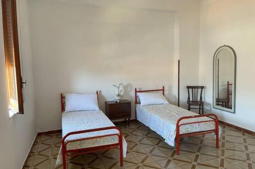 een kamer met 2 bedden en een spiegel bij Amplio e luminoso appartamento nel cuore di Le Castella in Le Castella