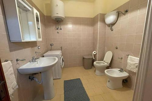een badkamer met een wastafel, een toilet en een spiegel bij Amplio e luminoso appartamento nel cuore di Le Castella in Le Castella
