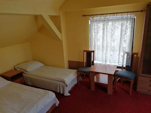 a room with two beds and a table and a window at Domek 8 osobowy PORTOWA PRZYSTAŃ 150m od plaży in Mrzeżyno