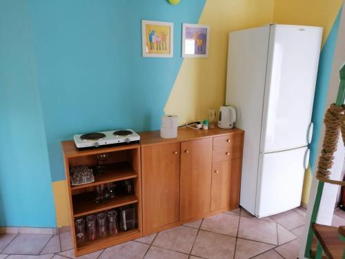 a kitchen with a white refrigerator and a brown cabinet at Domek 8 osobowy PORTOWA PRZYSTAŃ 150m od plaży in Mrzeżyno
