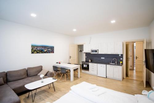 a living room with a couch and a kitchen at Apartmány Velké náměstí in Kroměříž