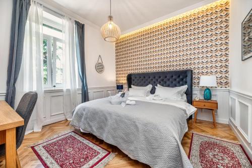 a bedroom with a bed and a wall covered in wallpaper at Evala luxury rooms with pool and garden in Split
