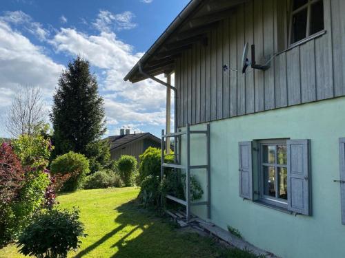 una casa bianca con una finestra sul lato di Ferienhaus Waldhaus a Grafenau