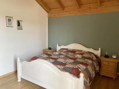 a bedroom with a white bed and a wooden ceiling at Ferienhaus Waldhaus in Grafenau