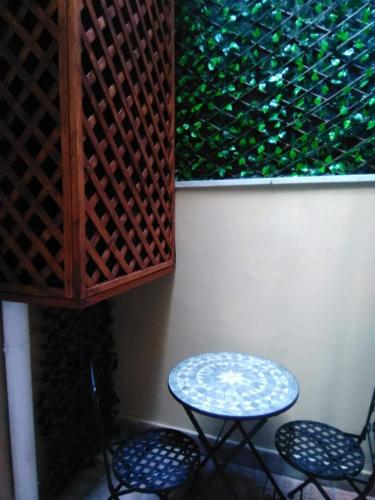 a table and two chairs next to a wall at Palazzo Iargia in Canicattini Bagni