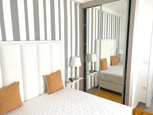 una camera da letto con un letto e un grande specchio di Duarte Houses - Casa T1 N - com vista mar a Nazaré