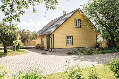 ein gelbes Haus mit einer steinernen Einfahrt in der Unterkunft Kunderi 16 Holiday House in Rakvere