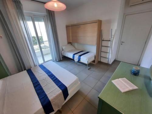 a bedroom with a bed and a desk and a window at Residence El Patio in Lido di Jesolo