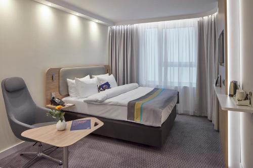 a hotel room with a bed and a table and a chair at Holiday Inn Express - Merzig, an IHG Hotel in Merzig