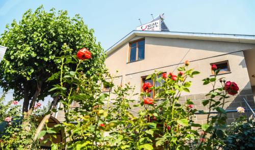 a building with red roses in front of it at Hayi Tun Guest House in Goris