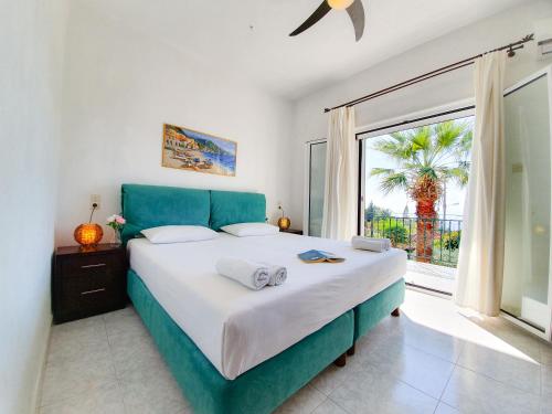 a bedroom with a large bed and a large window at Giovanni Group Apartments in Syvota