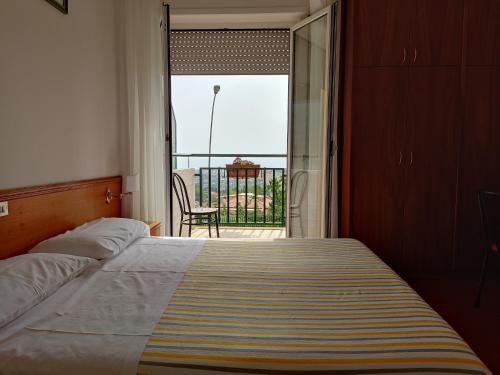 a bedroom with a bed and a view of a balcony at Hotel Ristorante Il Grillo in Acquaviva Picena