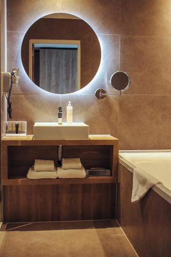 a bathroom with a sink and a mirror at Van der Valk Hotel Breda in Breda