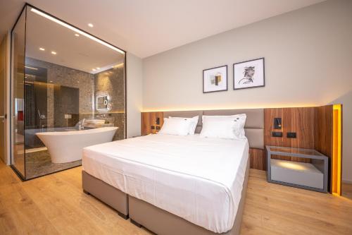 ein Schlafzimmer mit einem großen Bett, einer Badewanne und einer Badewanne in der Unterkunft Fiore Hotel in Kavajë