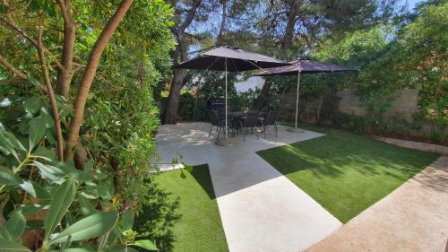 ノヴァリャにあるHoliday Home Darkoのパティオ(パラソル2本、テーブル、椅子付)