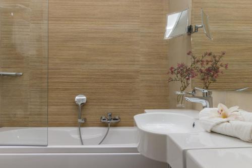a bathroom with a tub and a sink and a shower at Hotel Italia in Cagliari