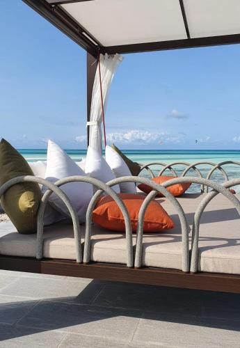a bed on a deck with a view of the ocean at Villa Bluu Zanzibar in Jambiani