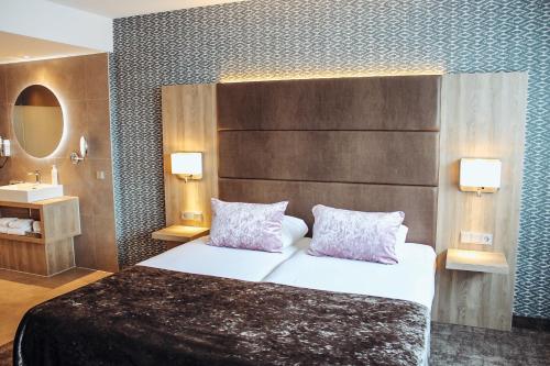a hotel room with a bed and a sink at Van der Valk Hotel Breda in Breda