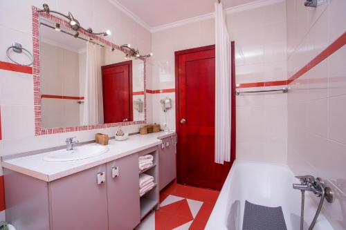 a bathroom with a sink and a red door at Spilia Bay Villas in Pefki