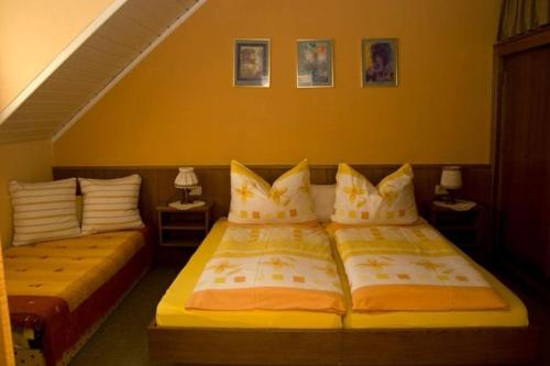 バート・クラインキルヒハイムにあるZur alten Schmiedeの黄色い壁のベッドルーム1室(ベッド2台付)