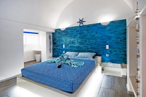 a bedroom with a blue accent wall and a bed at Blue Dream - Santorini in Kamari