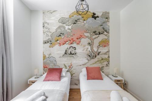 two beds in a room with a wall mural at Les Lauriers - dans l'Intramuros in Saint Malo