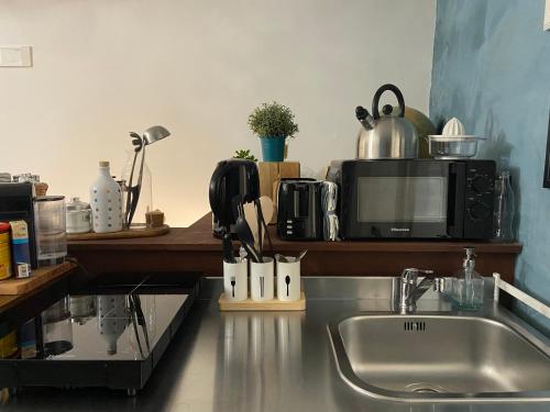a kitchen counter with a sink and a microwave at Casa Velata a Spaccanapoli in Naples