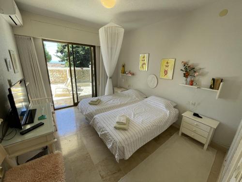 1 dormitorio con 1 cama, TV y ventana en Montepino 48, en La Herradura