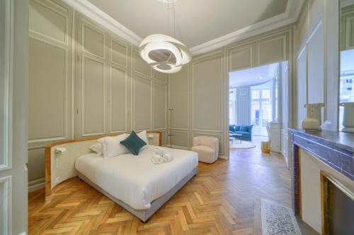 - une chambre avec un lit blanc et une cheminée dans l'établissement Le Paradoxe - Magnifique appartement de 80m2, à Bordeaux