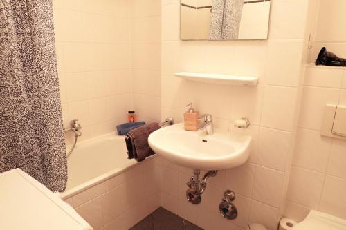 a bathroom with a sink and a toilet and a tub at FULL HOUSE Studios - Westside Apartment - Nescafé inkl in Leipzig