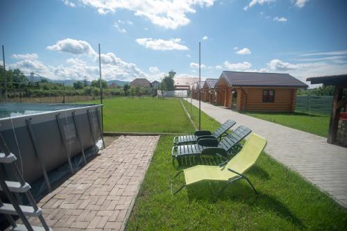 a group of benches sitting on the grass near a building at Christiana-Rent in Cristian