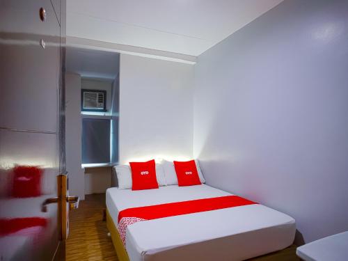 Schlafzimmer mit einem Bett mit roten und weißen Kissen in der Unterkunft OYO 793 Dg Budget Hotel Salem in Manila