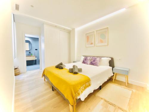 a bedroom with a bed with a yellow blanket on it at Casa Natura Elx in Elche