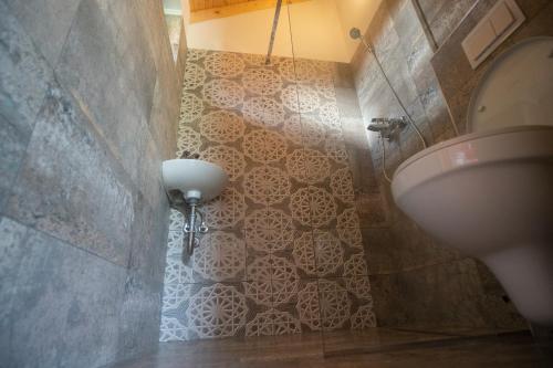 a bathroom with a toilet and a tiled wall at Christiana-Rent in Cristian