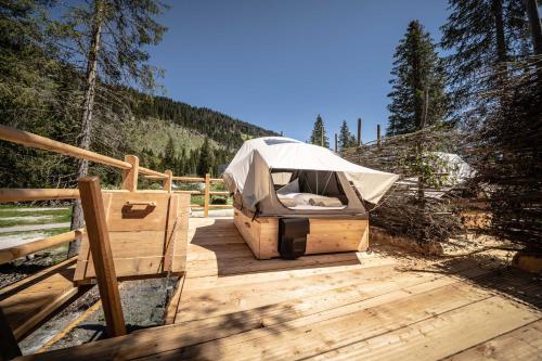 a tent sitting on a wooden deck in the woods at Caravan Park Sexten in Sesto