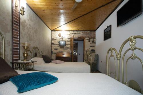 a bedroom with two beds and a tv on the wall at Старата баkалия The old grocery, guest rooms in Balchik